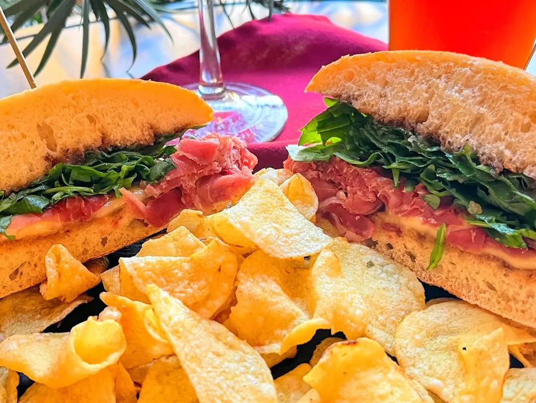 Brie and Prosciutto Panino with fig spread, melted brie and greens on ciabatta