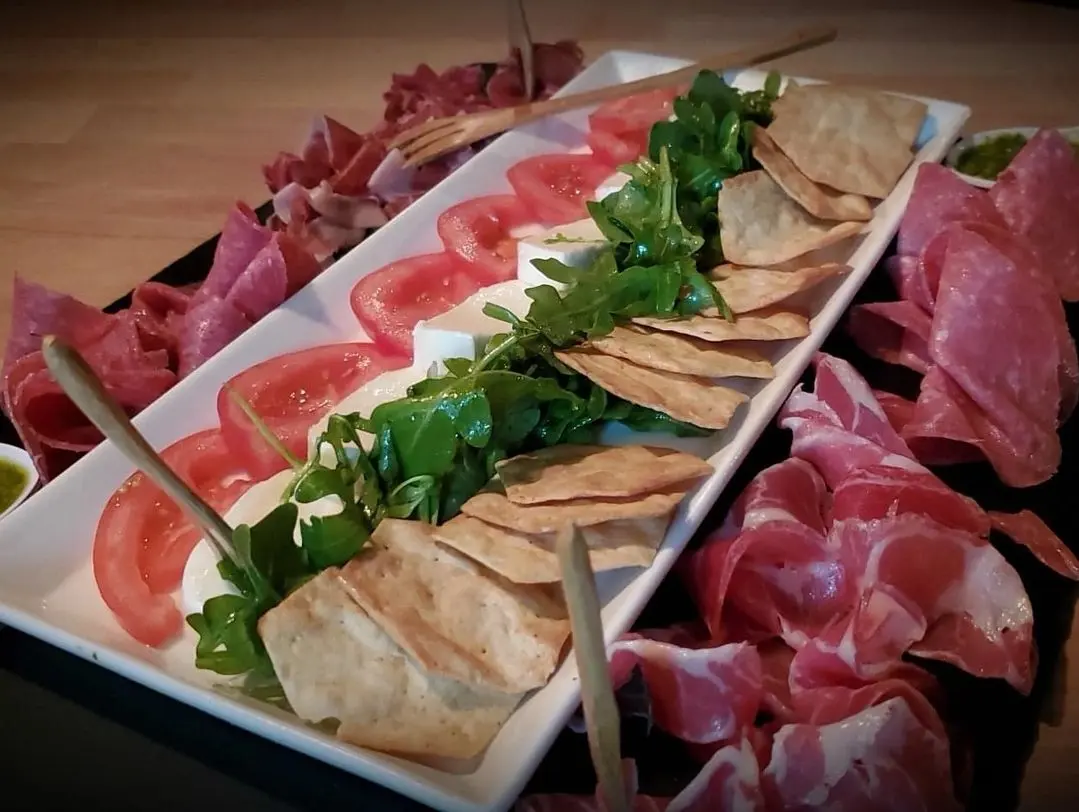 The Pope board with prosciutto, soppressata, capicola, mozzarella, tomatoes and basil pesto