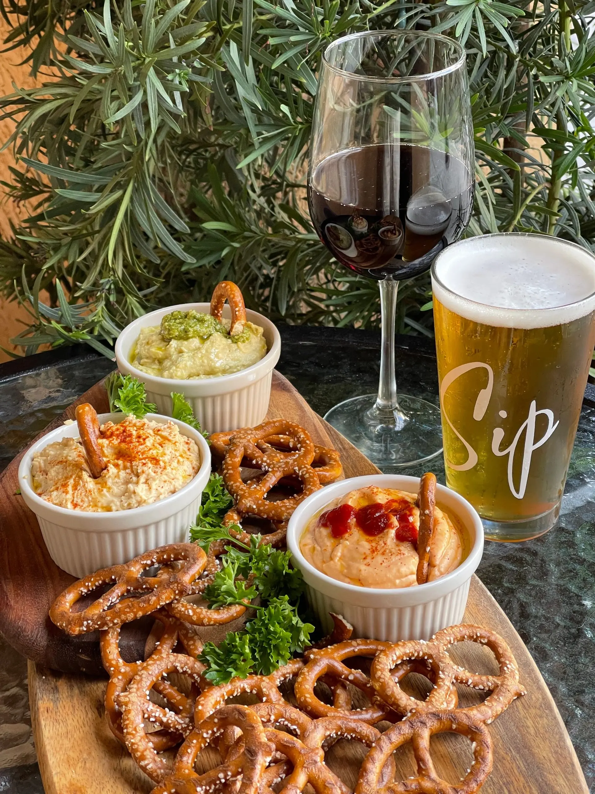 Pretzel bites with dipping sauces alongside beer and wine